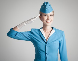 Charming Stewardess Dressed In Blue Uniform On Gray Background