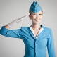 Charming Stewardess Dressed In Blue Uniform On Gray Background